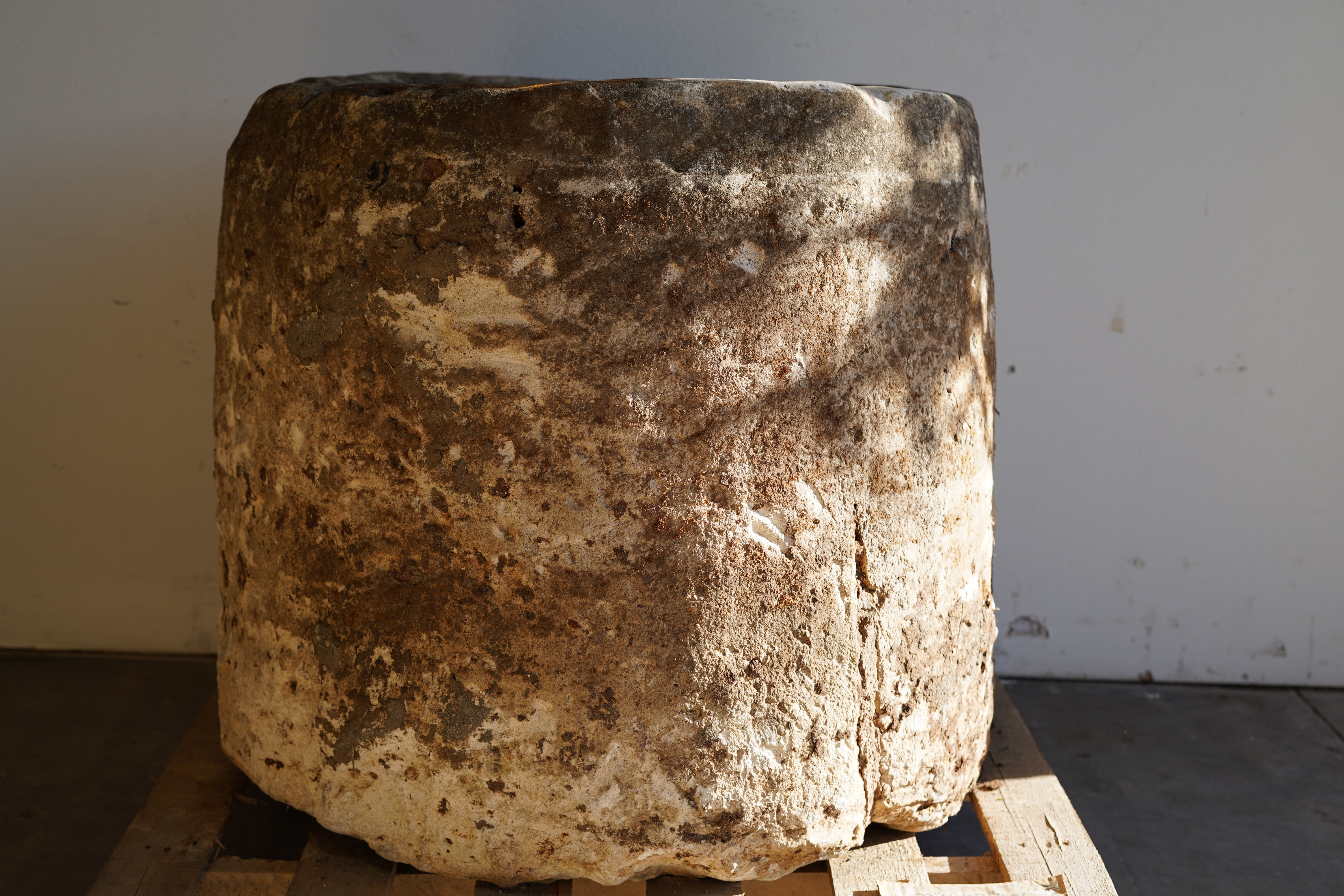 Close up view of front of Antique Hand Carved Limestone Round Planter which can be converted into a beautiful fountain or fire pit. Dimensions: 32" H x 37" W. In partial sunlight