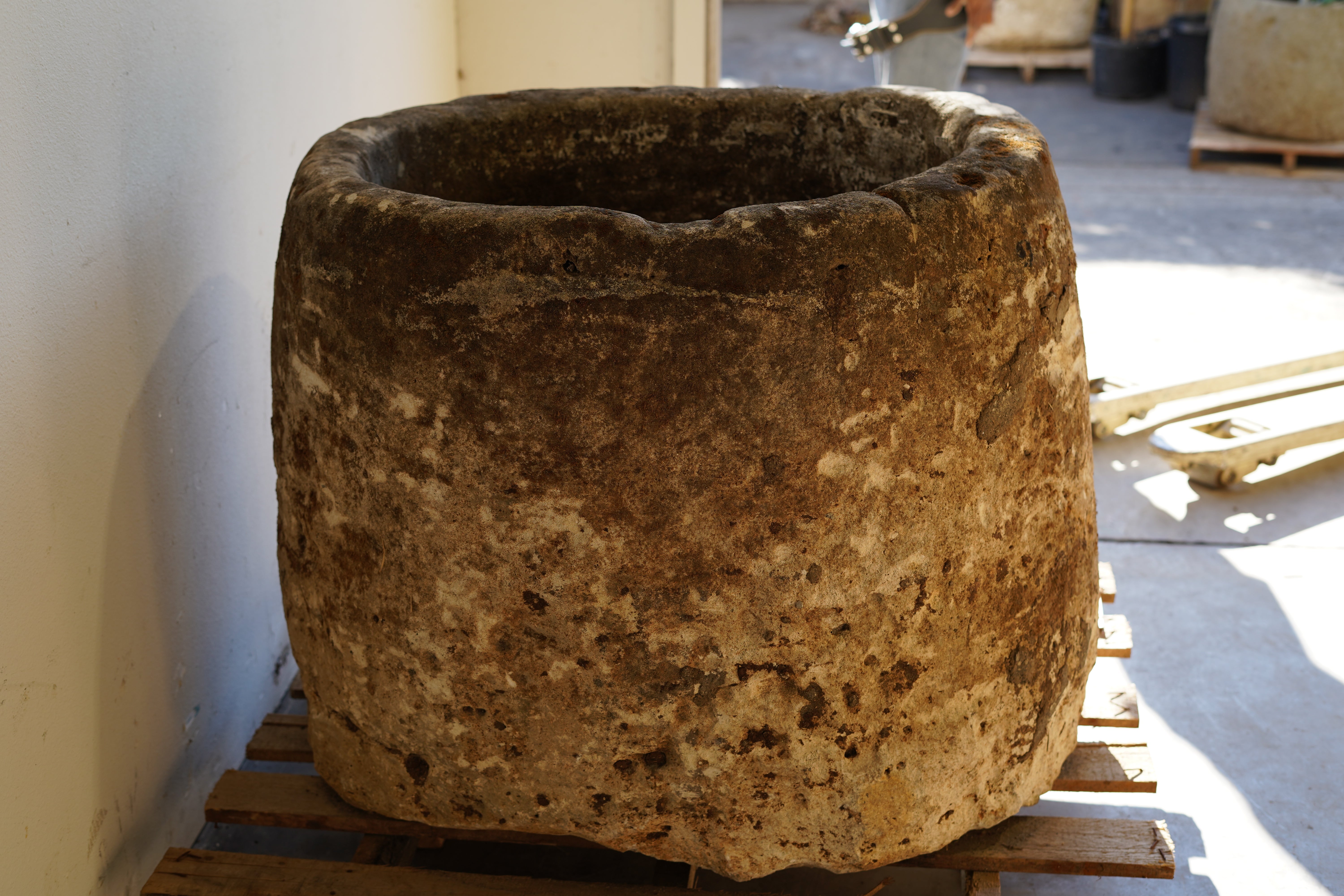 Side view of Antique Hand Carved Limestone Round Planter which can be converted into a beautiful fountain or fire pit. Dimensions: 32" H x 37" W. In partial sunlight