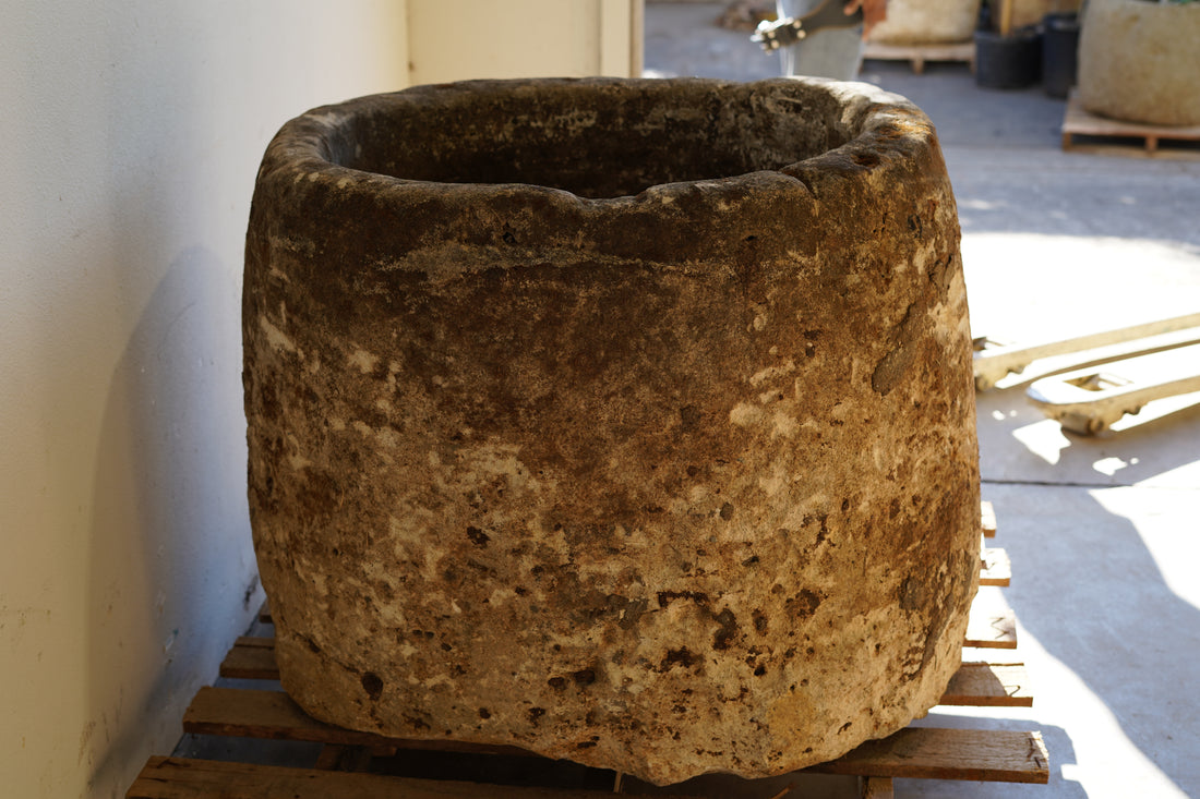 Side view of Antique Hand Carved Limestone Round Planter which can be converted into a beautiful fountain or fire pit. Dimensions: 32" H x 37" W. In partial sunlight