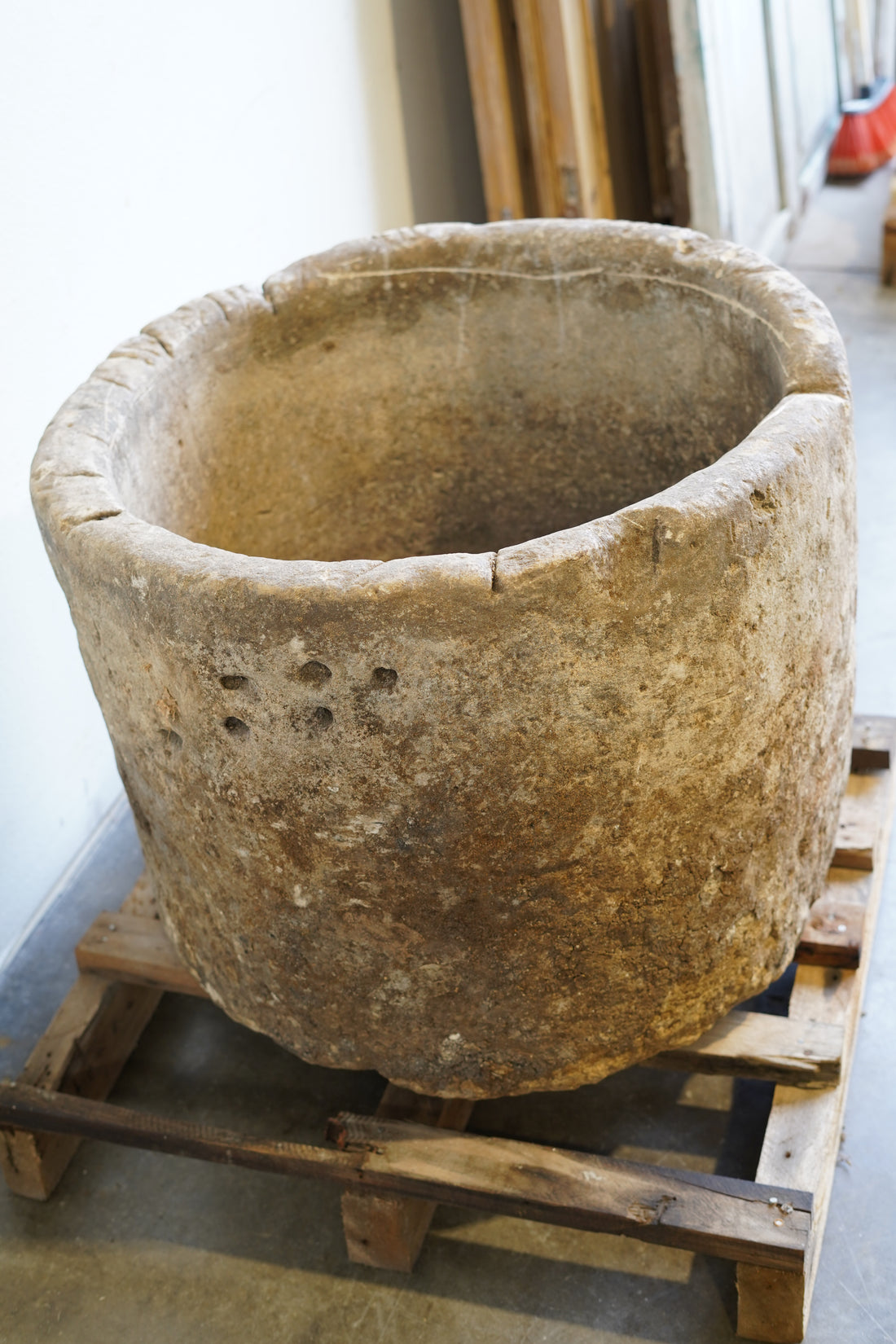 side view of antique limestone vessel with nail holes and beautiful rustic character.