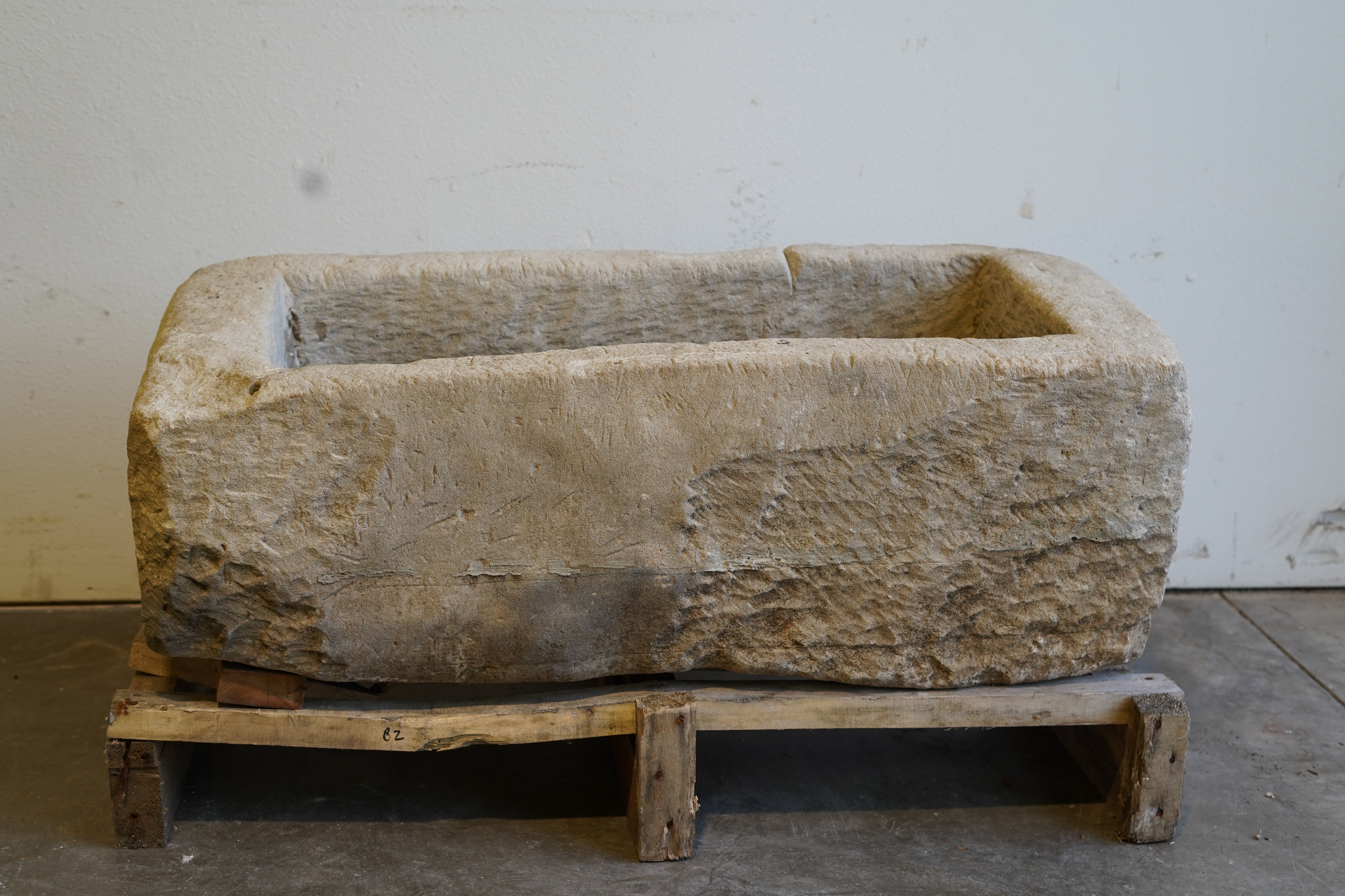 Wide angle of limestone planter showcasing full rectangular shape and aged character