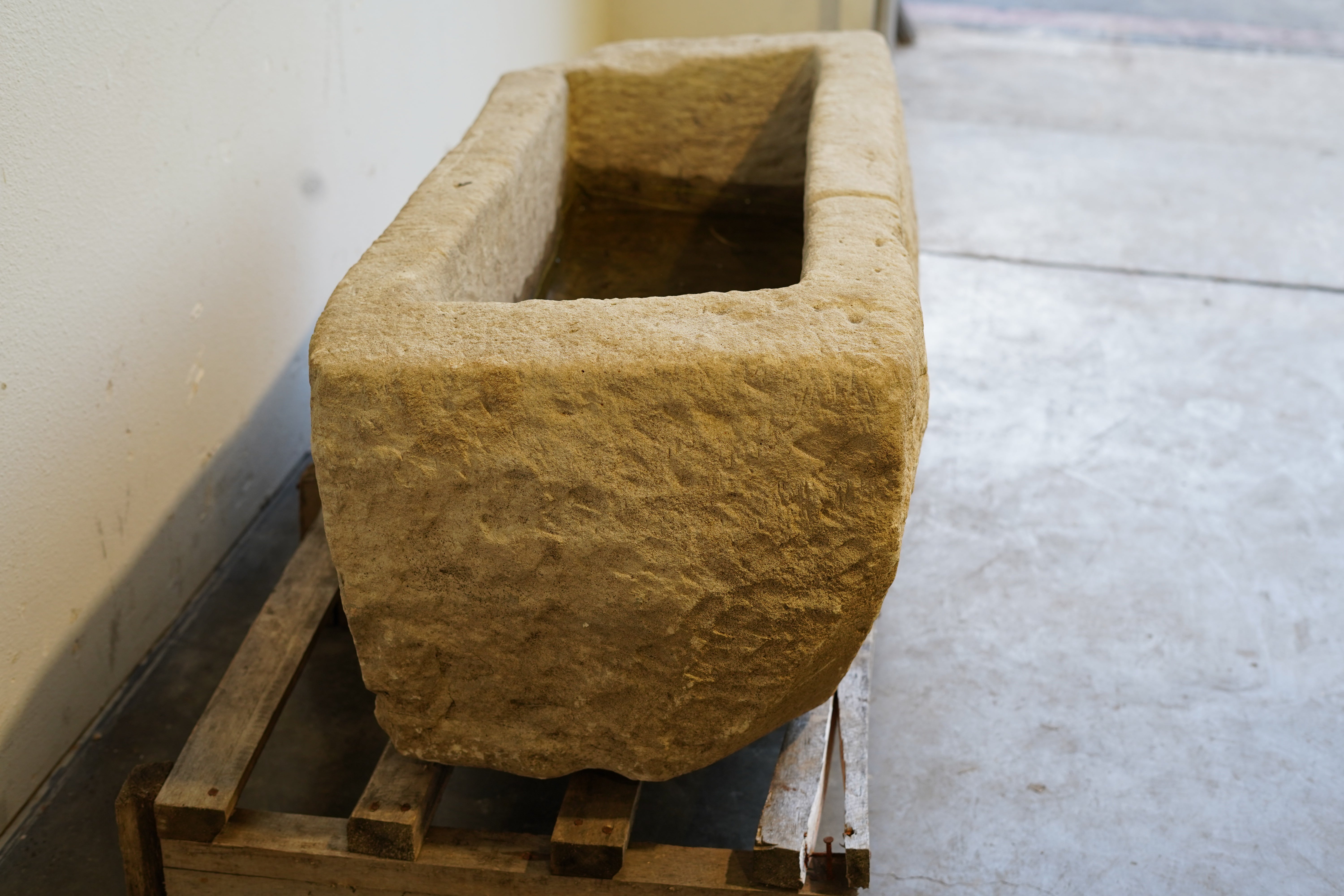 Wide angle of limestone planter showcasing full rectangular shape and aged character