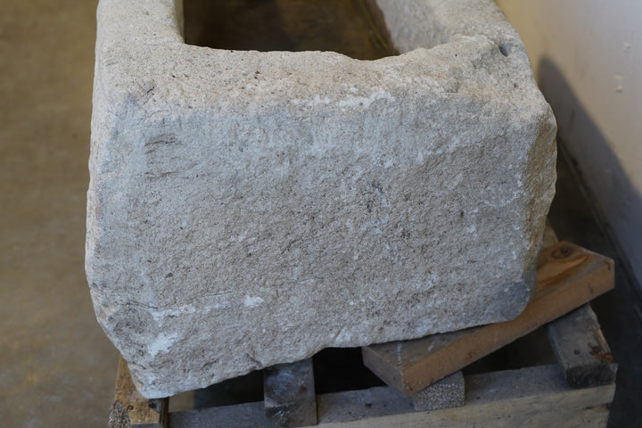 Detail shot of stone edge and moss-toned color variations on antique limestone trough
