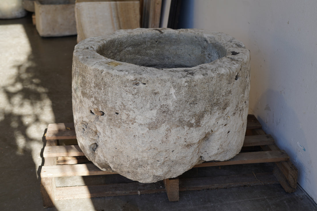 side view in shaded lighting of Antique Limestone Planter - Round. Dimensions: 18" H x 28" W