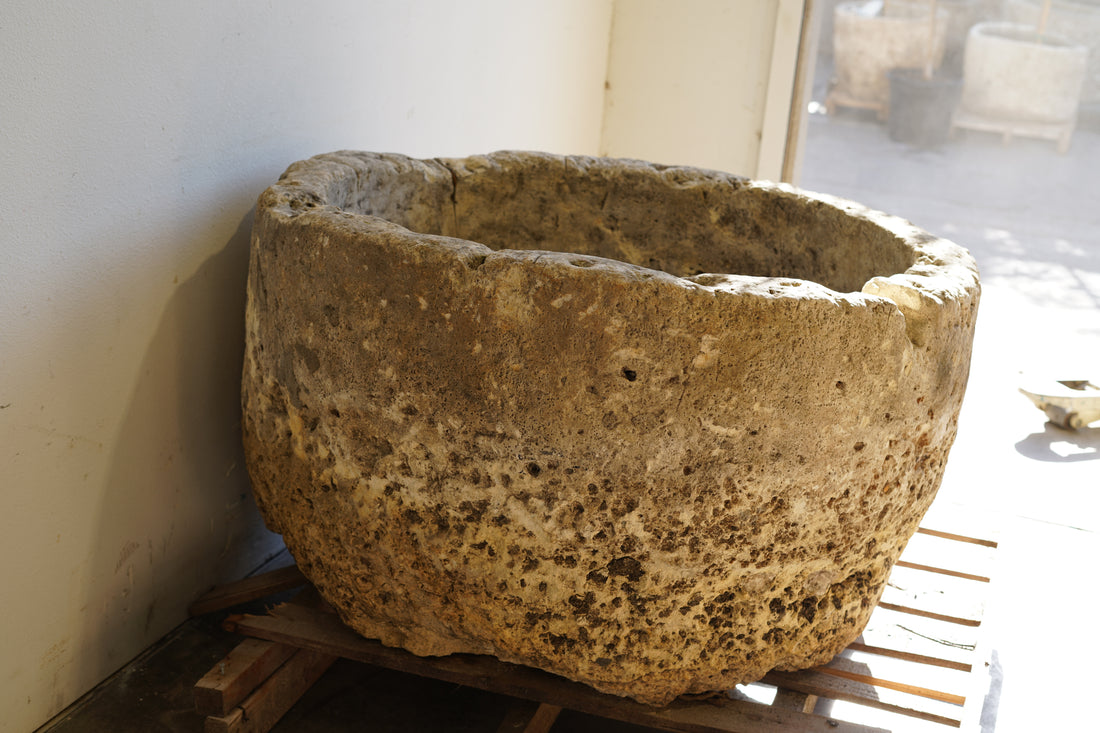 side view of extra large limestone round planter, hand carve and naturally aged over decades of use .
