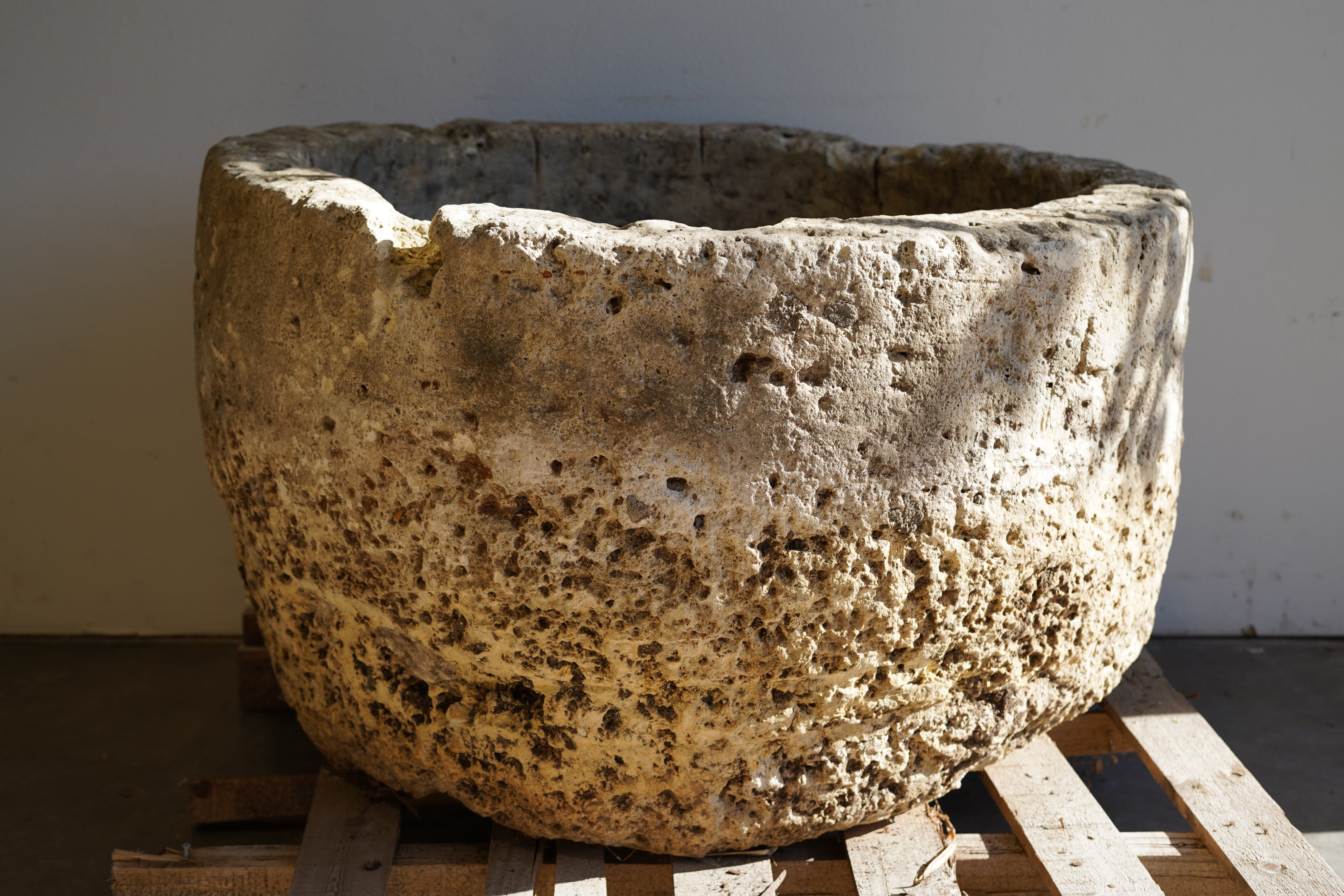 Natural patina and aging on an extra large wide, antique hand-carved limestone planter.