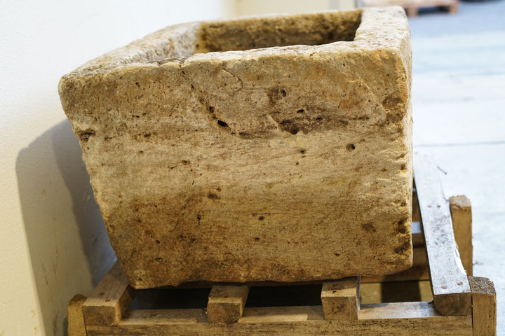 Side view of antique limestone trough planter with aged patina, hand-carved rectangular design measuring 30L x 24W x 16H inches, perfect for rustic gardens or farmhouse-style interiors.