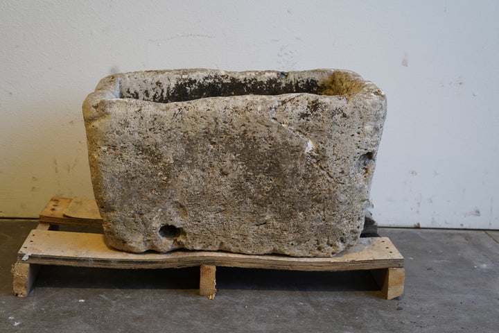 Top view of large limestone trough planter with visible interior and drainage channel