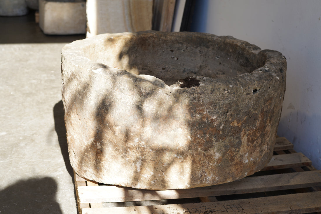 Antique Round Hand-Carved limestone with natural patina and aging over decades. Dimensions: 17" H x 33" W. Shadows from trees outside.
