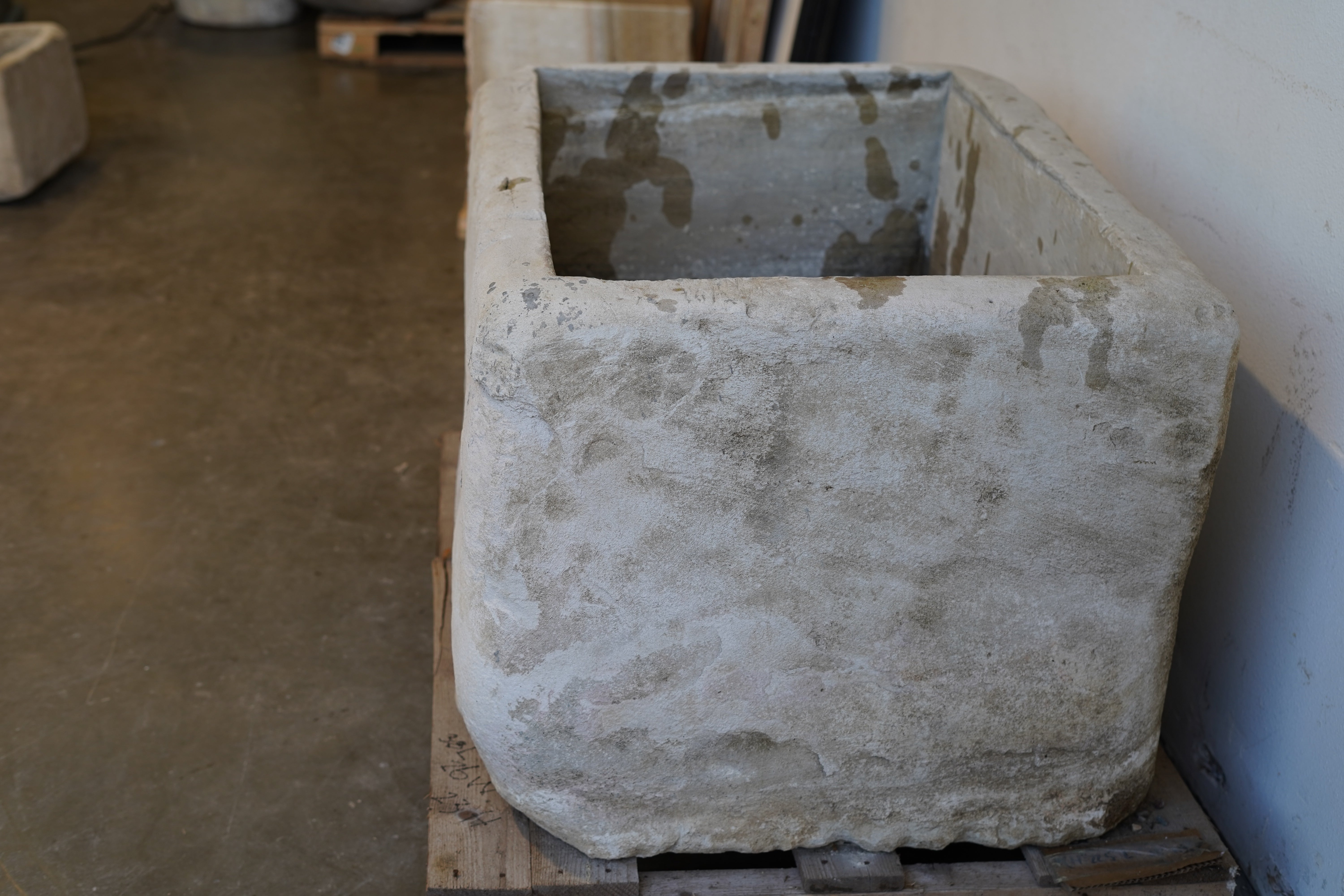 Close-up of vintage limestone planter texture and chiseled stone detailing.