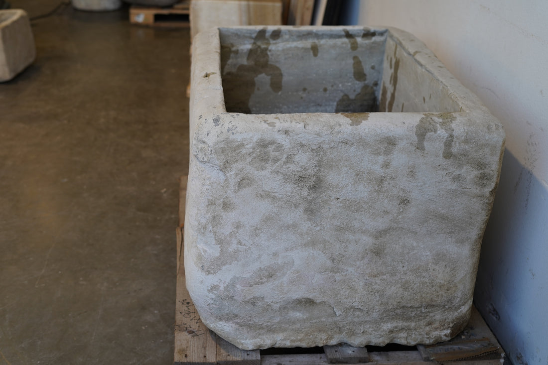 Close-up of vintage limestone planter texture and chiseled stone detailing.