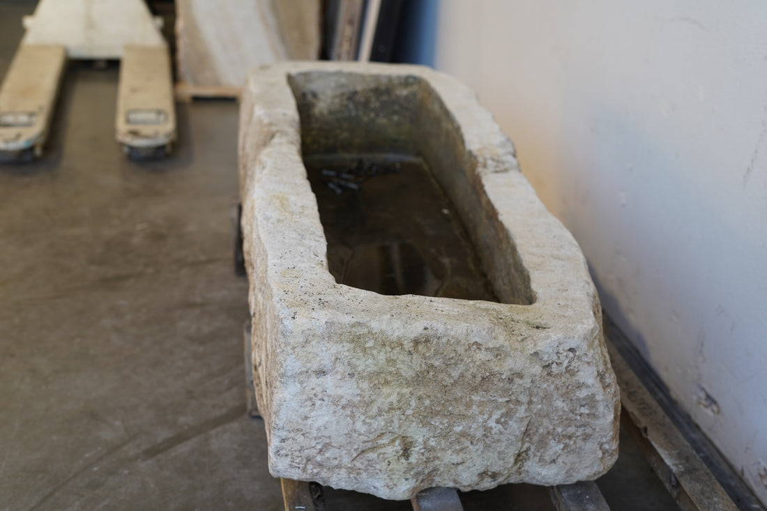 Close-up of vintage limestone garden planter showing hand-carved detail and natural aging