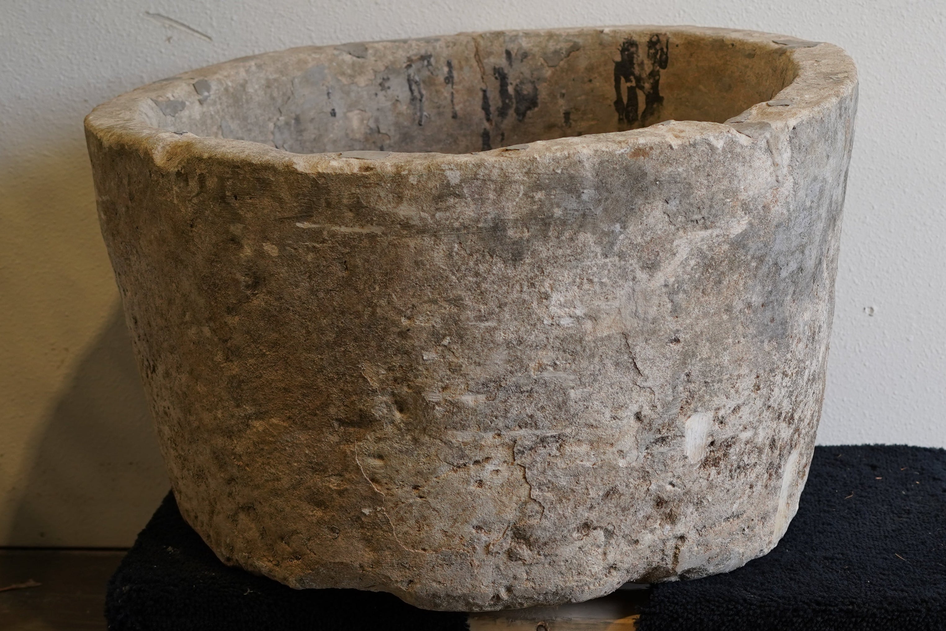 Close up of vintage limestone hand-carved round limestone planter. Natural aging and wear and tear from decades of use in Indonesia.