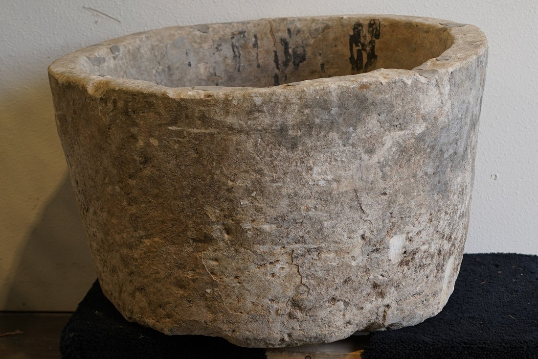 Close up of vintage limestone hand-carved round limestone planter. Natural aging and wear and tear from decades of use in Indonesia.