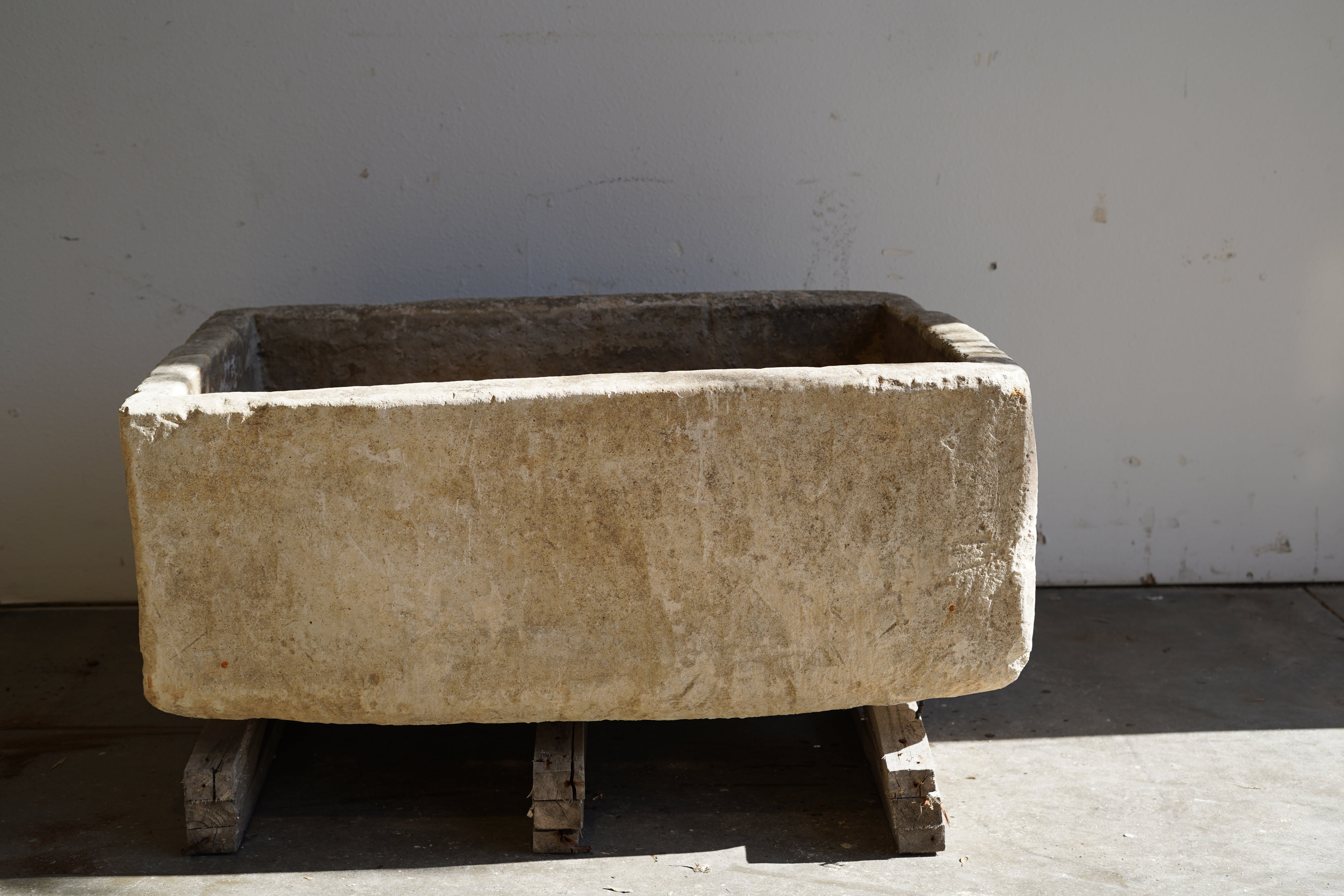 Backside of Vintage Limestone Trough in natural lighting. Dimensions: 37.5" L x 25" W x 16.5" H
