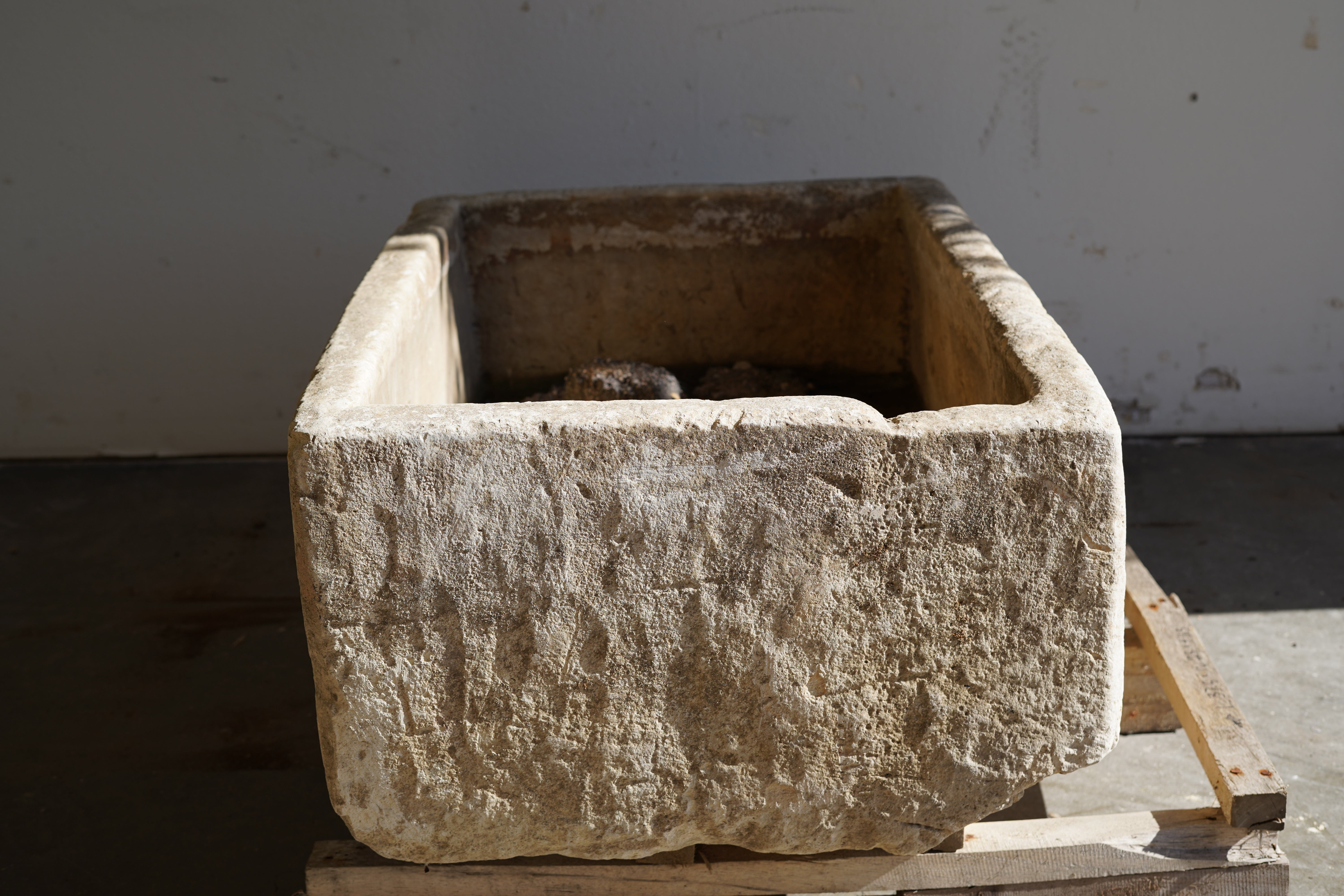 Side view in natural sunlight of Vintage Limestone Trough in natural lighting. Dimensions: 37.5" L x 25" W x 16.5" H