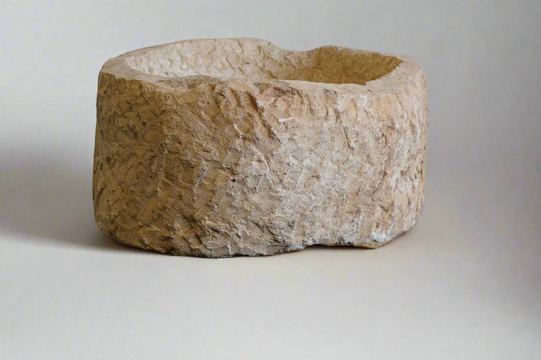 front view of round hand-carved authentic vintage limestone planter with plain white backdrop
